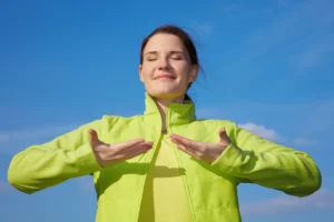 Kobieta oddychająca w zielonej bluzie podczas sesji oddechowej
