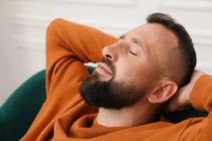 Mężczyzna w pomarańczowej koszulce relaksuje się na fotelu
